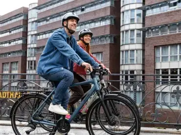 Mann und Frau fahren Fahrrad, beide tragen Helme.