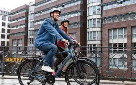 Mann und Frau fahren Fahrrad, beide tragen Helme.