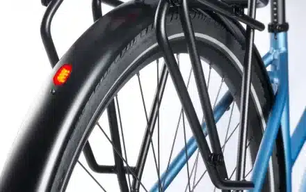 Detailaufnahme des roten Rücklichts am schwarzen Schutzblech eines blauen Aviolo 8.1 HT Tourenrads mit Gepäckträger.