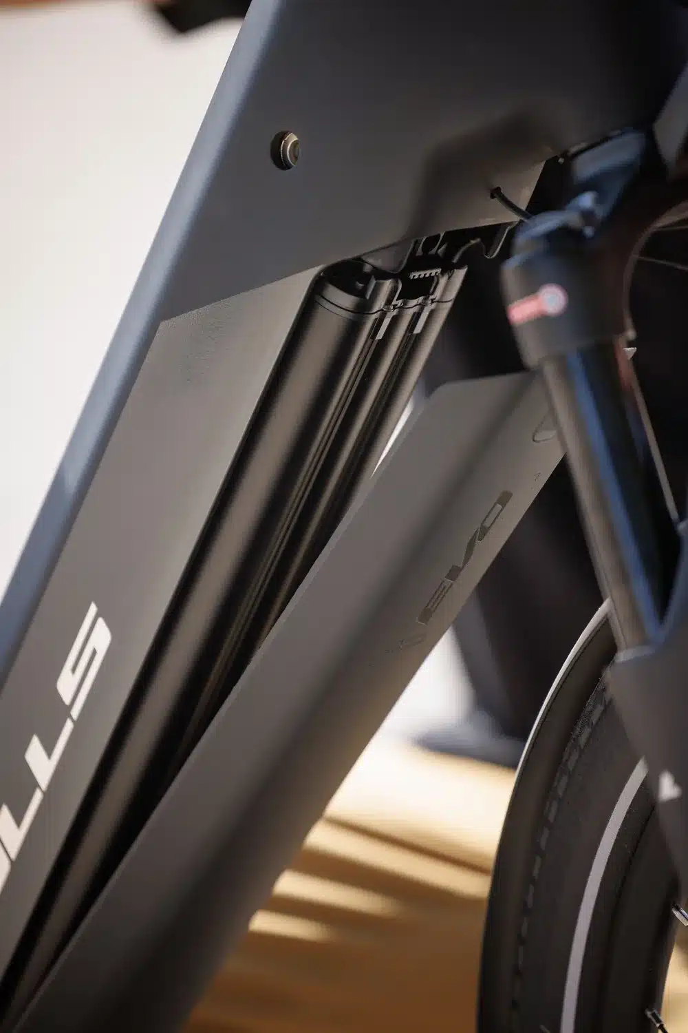 Nahaufnahme des Rahmens eines schwarzen Bulls Cross Lite EVO Carbon E-Bikes, wobei der integrierte Akku und die Vorderradgabel sichtbar sind. Der Schriftzug