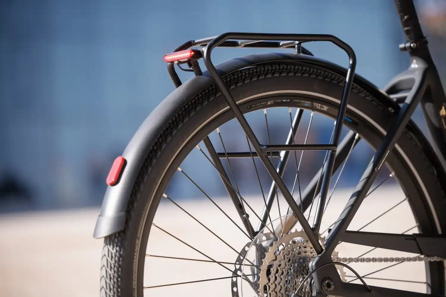 Detailaufnahme des Hinterrads mit Schutzblech, Gepäckträger und integriertem Bremslicht eines Bulls Cross Lite EVO Carbon E-Bikes.