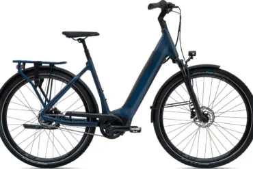 Seitenansicht eines dunkelblauen Giant DailyTour E+ 1 RT Trekking-E-Bikes mit Gepäckträger und Schutzblechen.