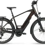 Seitenansicht eines braunen Stevens E-Triton 8.8.1 Plus Trekking-E-Bikes mit schwarzem Gepäckträger, Federgabel und breiten Reifen.