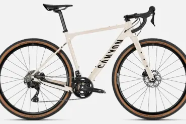 Canyon Grizl AL 7 Gravel-Bike in heller Sandfarbe mit schwarzen Akzenten, ausgestattet mit DT Swiss Laufrädern und Schwalbe G-One Reifen.