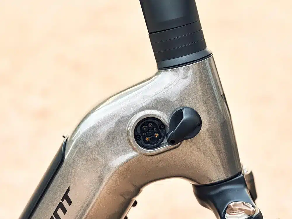 Nahaufnahme des Anschlusses zum Laden des Akkus am Rahmen eines grau-metallicfarbenen Giant AnyTour E+ 1 E-Bikes.