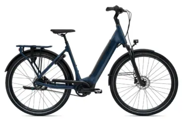 Dunkelblaues Giant DailyTour E+ 1 BD LDS E-Bike mit Gepäckträger, Schutzblechen und integriertem Licht, aufgenommen im Studio.