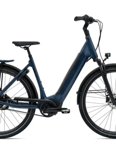Dunkelblaues Giant DailyTour E+ 1 BD LDS E-Bike mit Gepäckträger, Schutzblechen und integriertem Licht, aufgenommen im Studio.