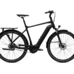 Vorder- und Seitenansicht eines schwarzen GIANT DailyTour E+ 2 E-Bikes auf weißem Hintergrund. Das Fahrrad verfügt über einen Gepäckträger, Schutzbleche, eine integrierte Frontleuchte und Scheibenbremsen.