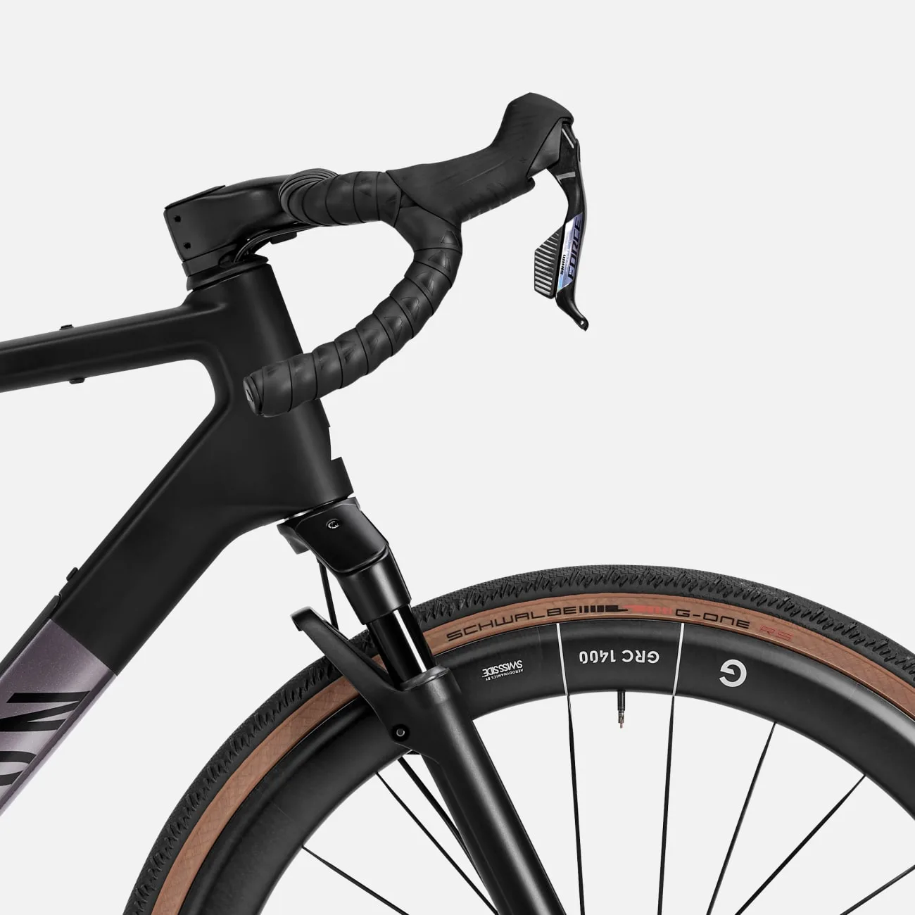 Detailbild eines schwarzen Canyon Grail CF SLX 8 w/ RIFT Gravelbikes mit Fokus auf das Cockpit, die RIFT-Federgabel und das Vorderrad mit Schwalbe G-One Reifen.
