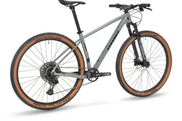 Graues Stevens Sonora Carbon Hardtail Mountainbike mit braunen Reifenprofilen, SRAM Antrieb und RockShox Federgabel.