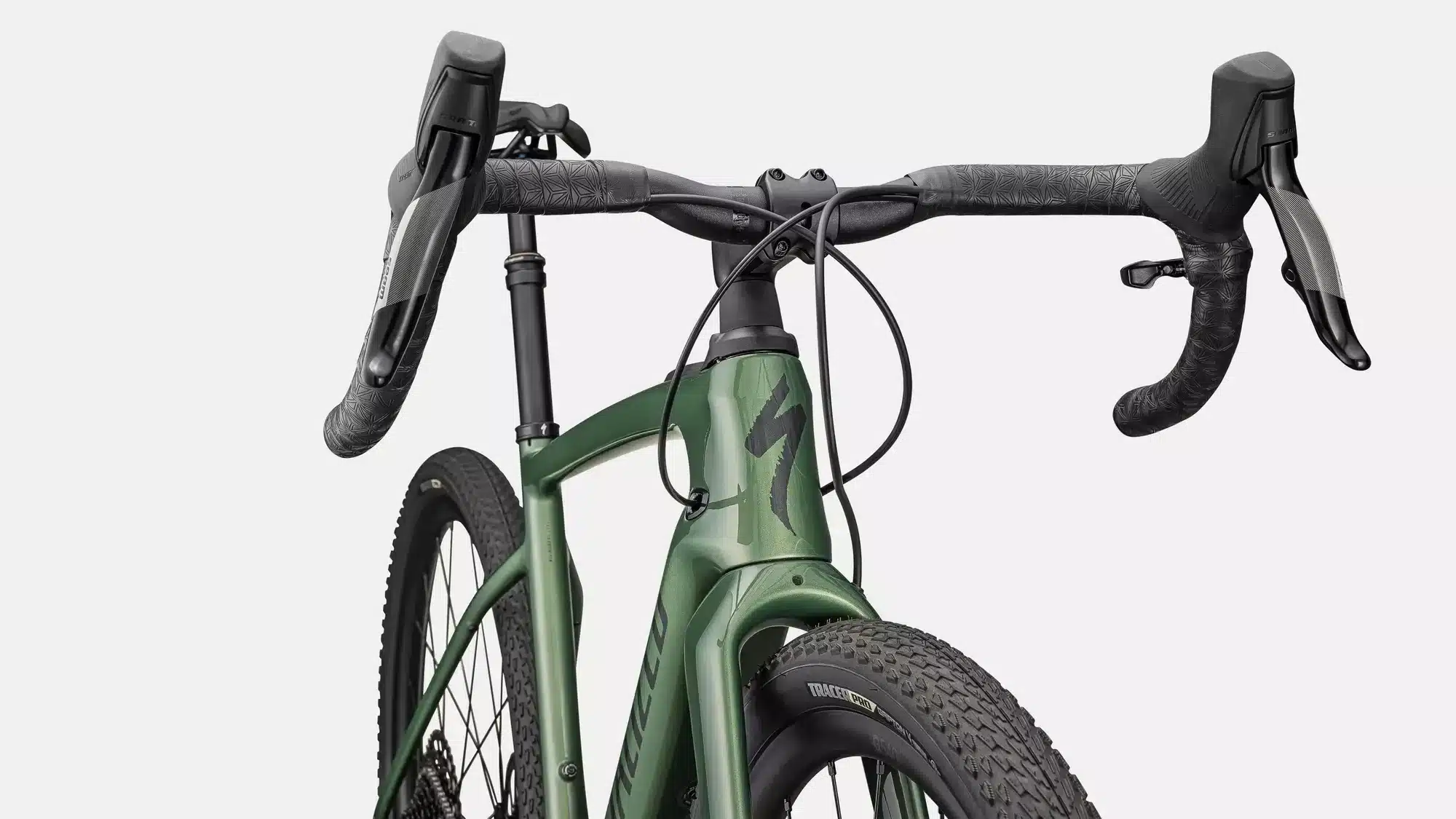 Grünes Specialized Turbo Creo 2 Comp E-Gravelbike mit SRAM Apex Schalthebeln, Specialized Logo auf dem Rahmen und grobstolligem Vorderreifen.