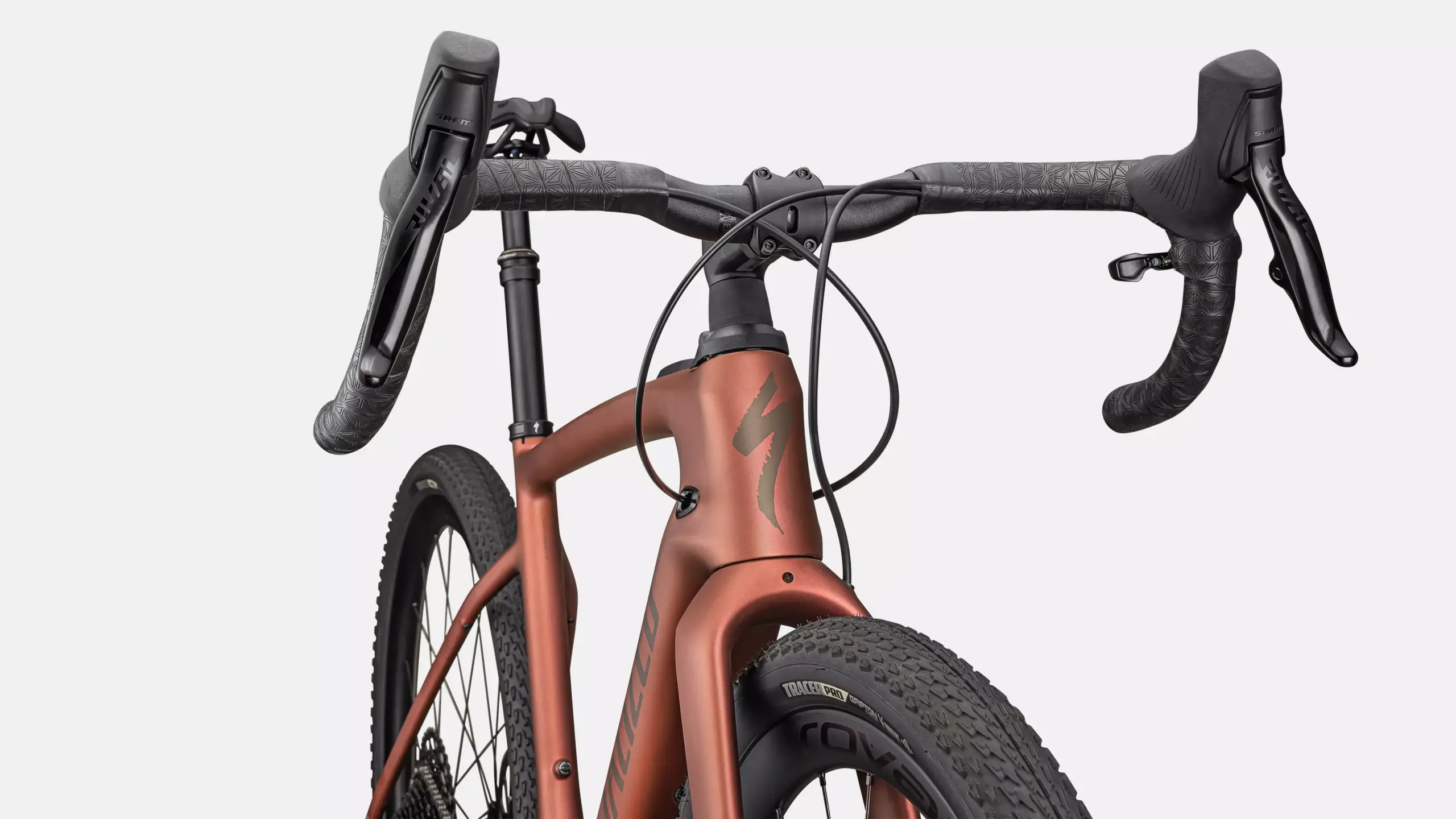 Detailaufnahme des Lenkers und des Rahmens eines orangefarbenen Specialized Turbo Creo 2 Expert E-Gravelbikes mit SRAM Rival AXS Komponenten.