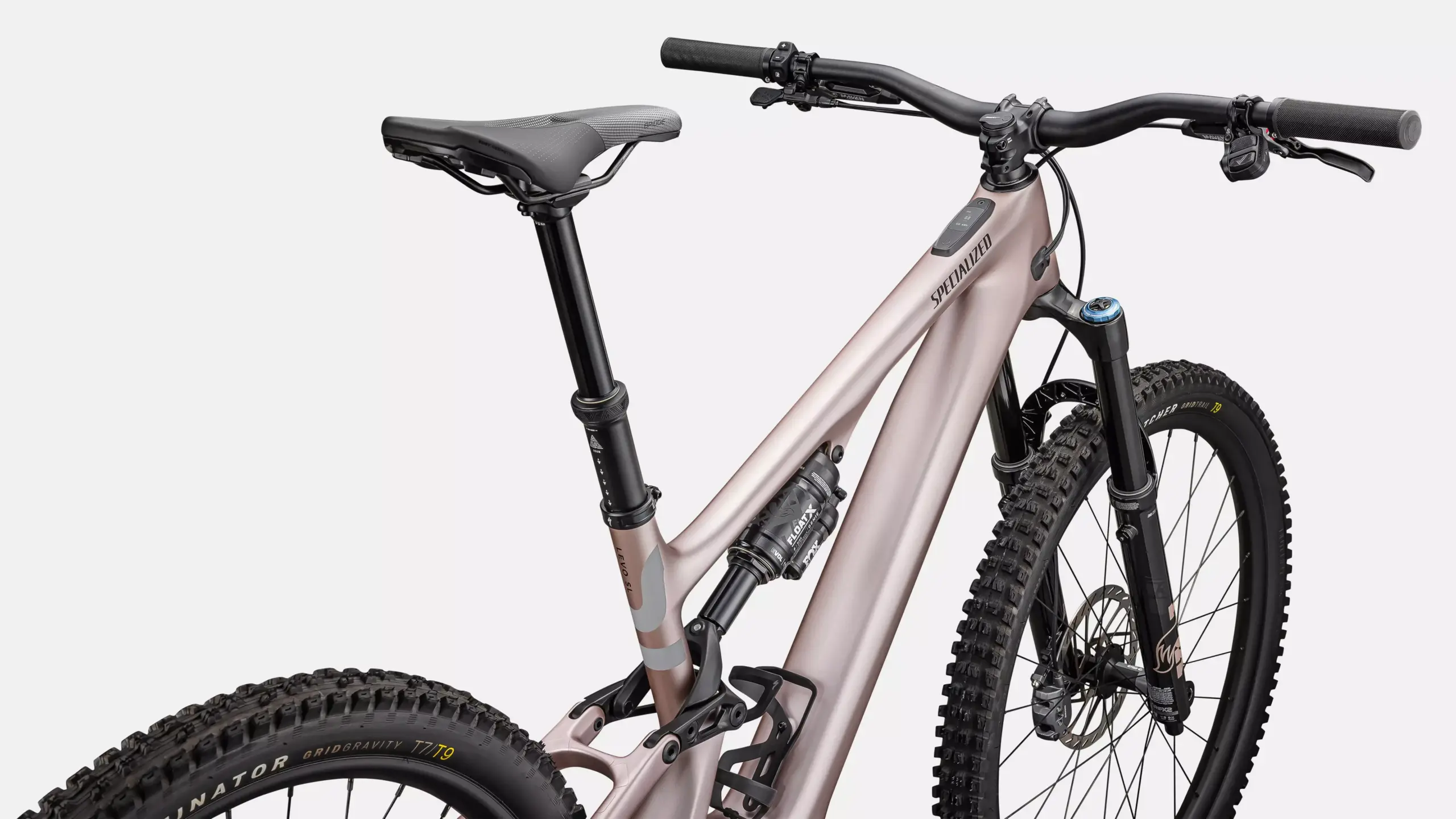 Detailansicht eines roségoldenen Specialized Turbo Levo SL 2 Expert E-Mountainbikes mit Fokus auf den Dämpfer und Teile des Rahmens.