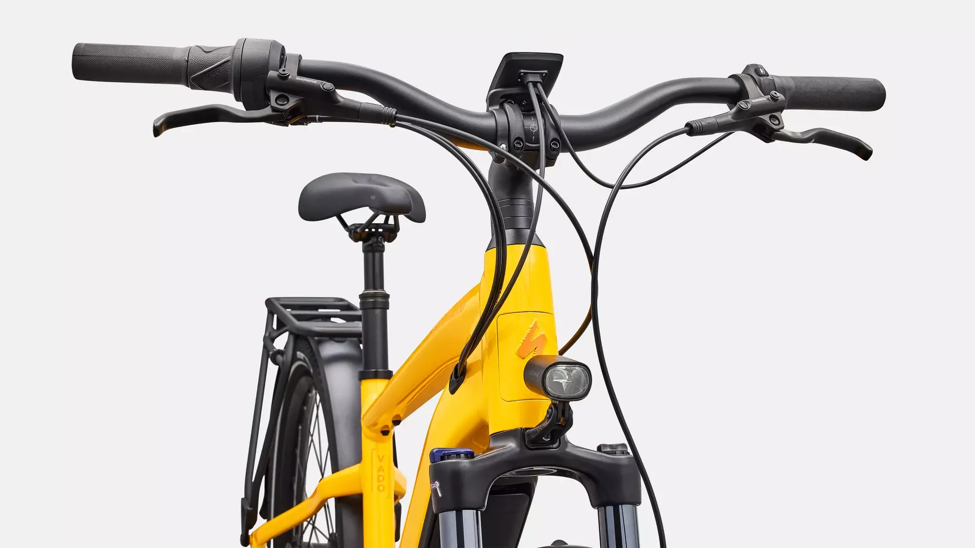 Detailaufnahme des gelben Specialized Turbo Vado 4.0 IGH E-Bikes mit Fokus auf das Lenkerende, die Bremshebel, das integrierte Display und die Frontfedergabel.
