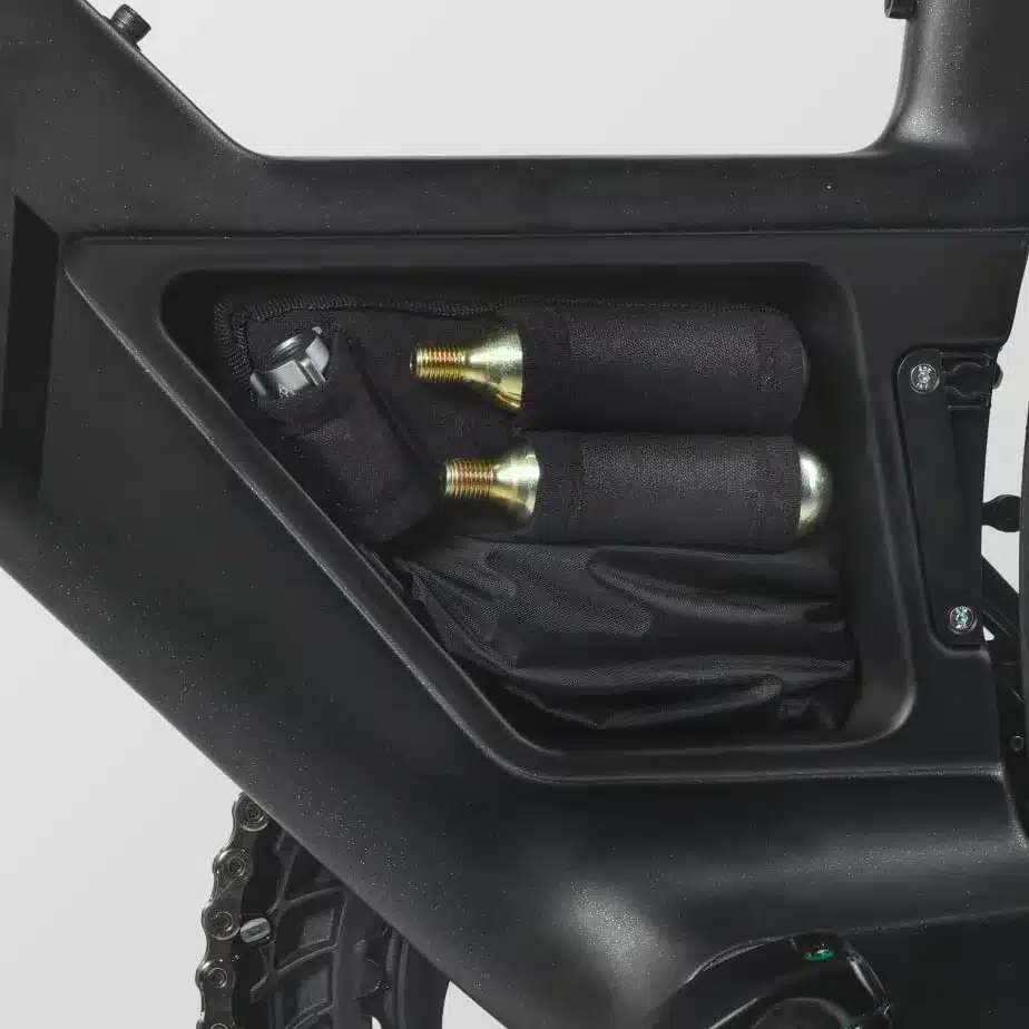 Nahaufnahme des integrierten Staufachs eines Canyon Speedmax Fahrradrahmens, das zwei CO2-Kartuschen und ein kleines Werkzeugpaket enthält.