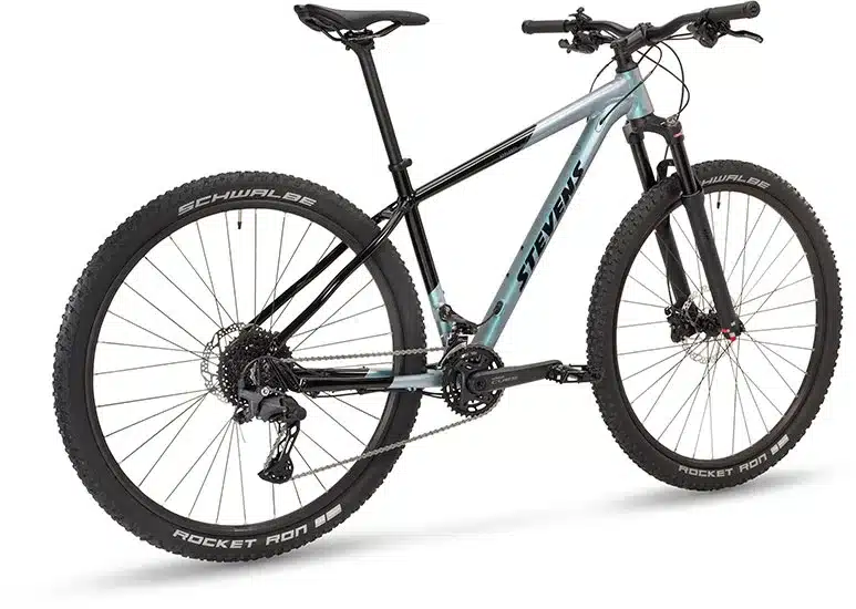 Seitenansicht eines Stevens Applebee Hardtail Mountainbikes in der Farbe Galactic Black mit blauen Akzenten.
