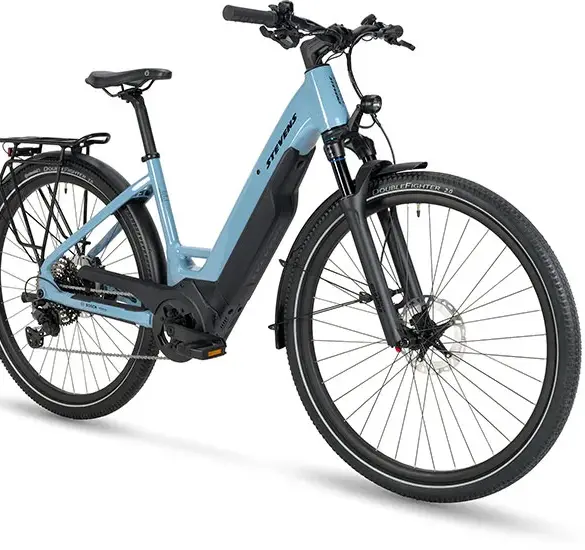 STEVENS E-8X Tour Plus Forma E-Tourenbike in hellblau mit schwarzem Gepäckträger und Reifen, freigestellt auf weißem Hintergrund.