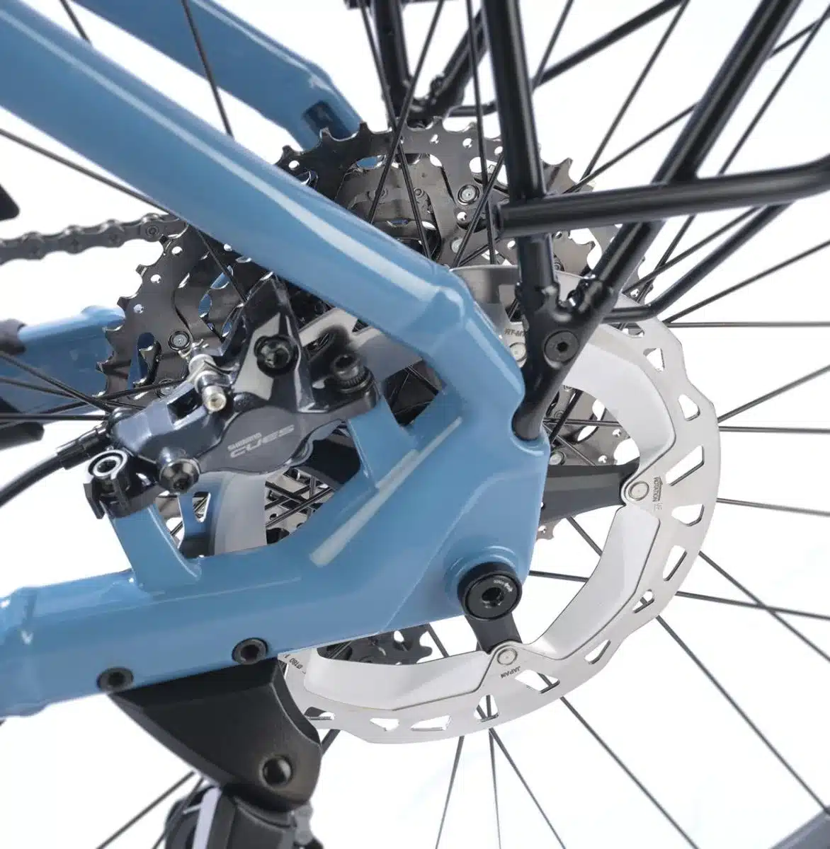 Detailaufnahme des Hinterrads eines blauen STEVENS E-8X Tour Plus Forma E-Bikes, Fokus auf die Disc-Bremse, Schaltung und den robusten Rahmen.