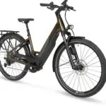 Ein Stevens E-Triton 8.8.1 Plus Forma Touren-E-Bike in Smoked Oak Brown mit tiefem Einstieg, ausgestattet mit Bosch Performance Line PX Antrieb, 800-Wh-Akku, Racktime-Gepäckträger und Supernova-Lichtanlage.