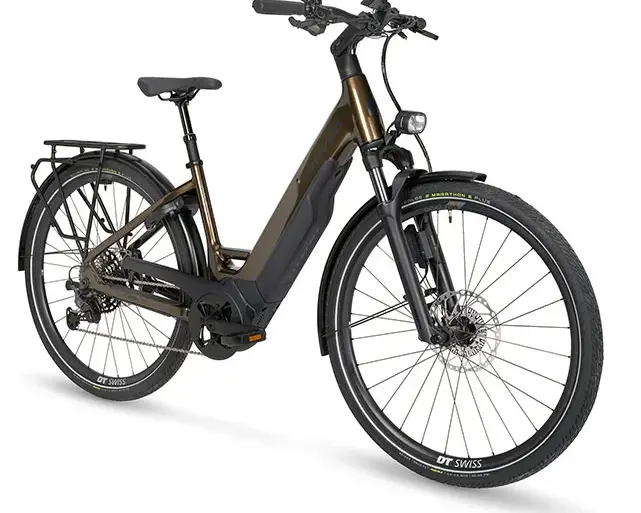 Ein Stevens E-Triton 8.8.1 Plus Forma Touren-E-Bike in Smoked Oak Brown mit tiefem Einstieg, ausgestattet mit Bosch Performance Line PX Antrieb, 800-Wh-Akku, Racktime-Gepäckträger und Supernova-Lichtanlage.