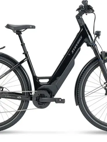Ein STEVENS E-Universe 7.7.1 Plus FEQ E-Crossover-Pedelec in Midnight Black steht vor einem weißen Hintergrund. Das Fahrrad ist mit einem Gepäckträger, Schutzblechen, Federgabel und einem integrierten Akku ausgestattet.