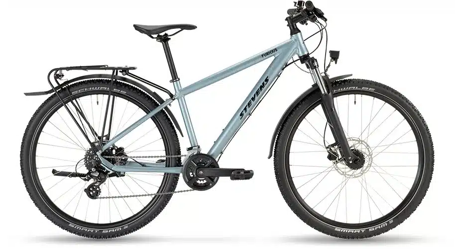 Seitenansicht des Stevens Furious Tour 27.5 Fahrrads in Hellblau mit Gepäckträger, Schutzblechen und Federgabel.