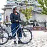 Stevens Kalea 7.1 LT Fahrrad mit Frau und Helm in städtischer Umgebung