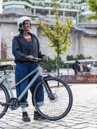 Stevens Kalea 7.1 LT Fahrrad mit Frau und Helm in städtischer Umgebung