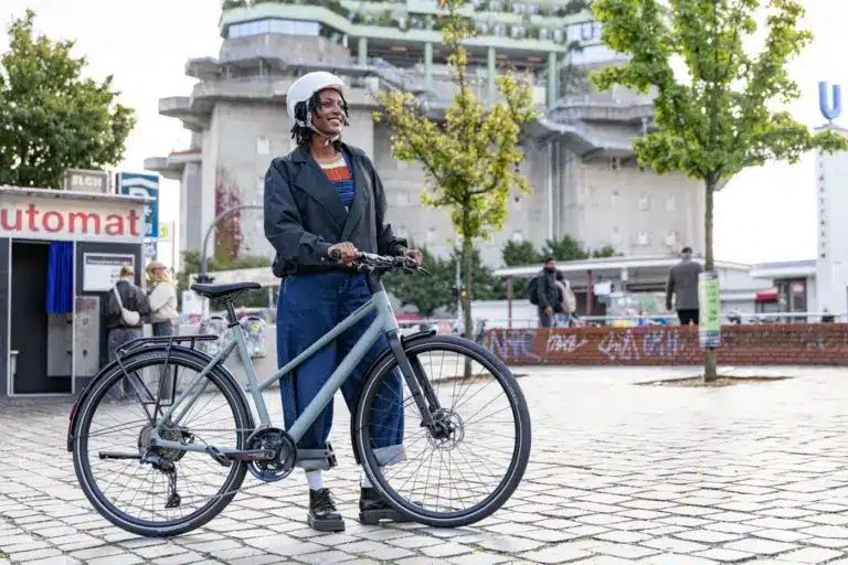 Stevens Kalea 7.1 LT Fahrrad mit Frau und Helm in städtischer Umgebung