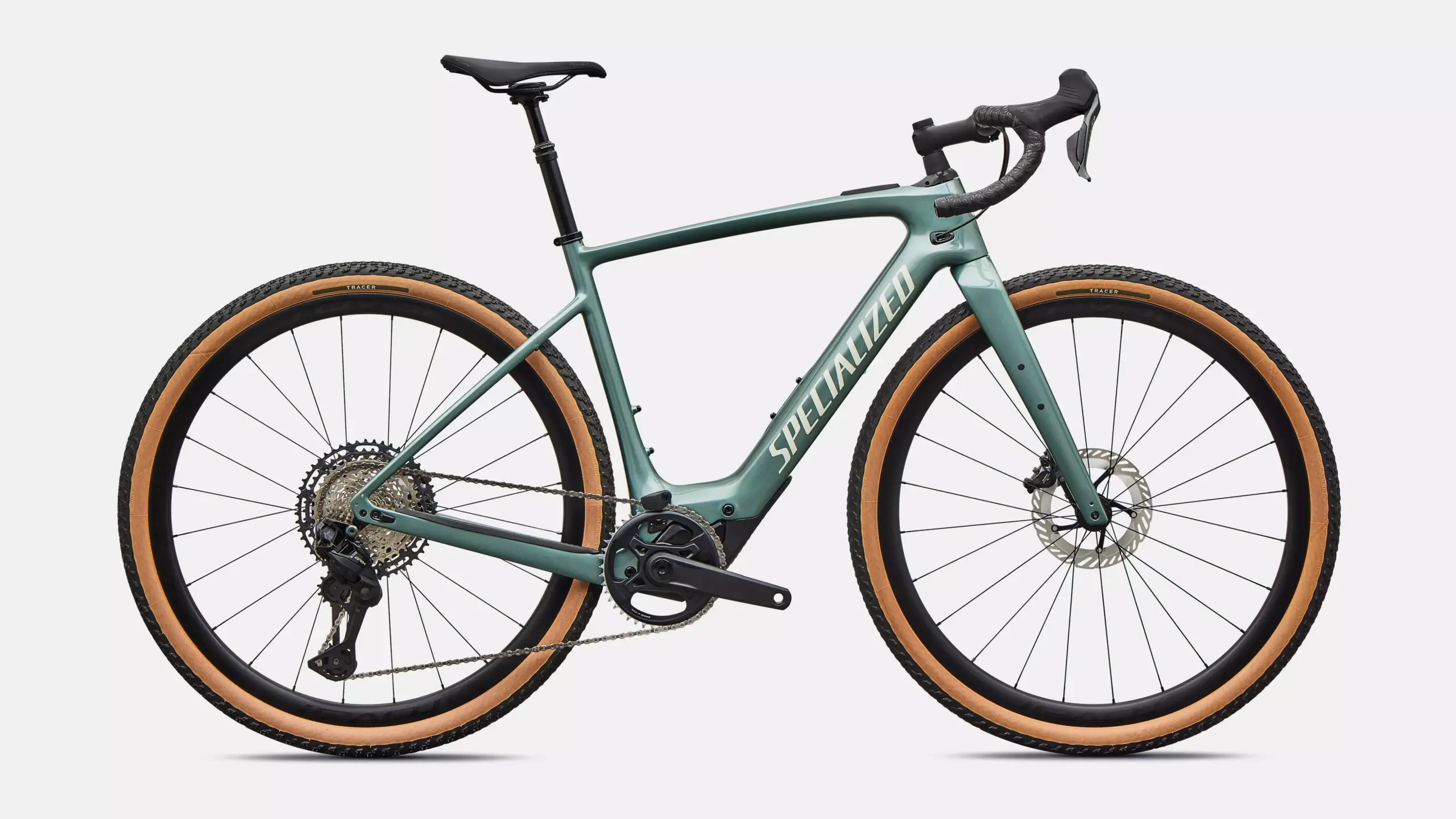 Seitenansicht eines grün-grauen Specialized Turbo Creo 2 Expert E-Gravelbikes mit braunen Reifen, schwarzem Lenker und Sattel.