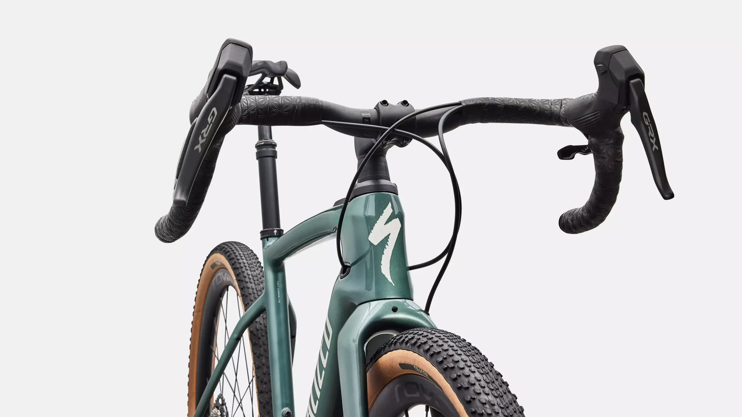 Detailansicht des grünen Specialized Turbo Creo 2 Expert E-Gravelbikes, Fokus auf Lenker, Bremsen und Vorderrad mit Profilreifen.