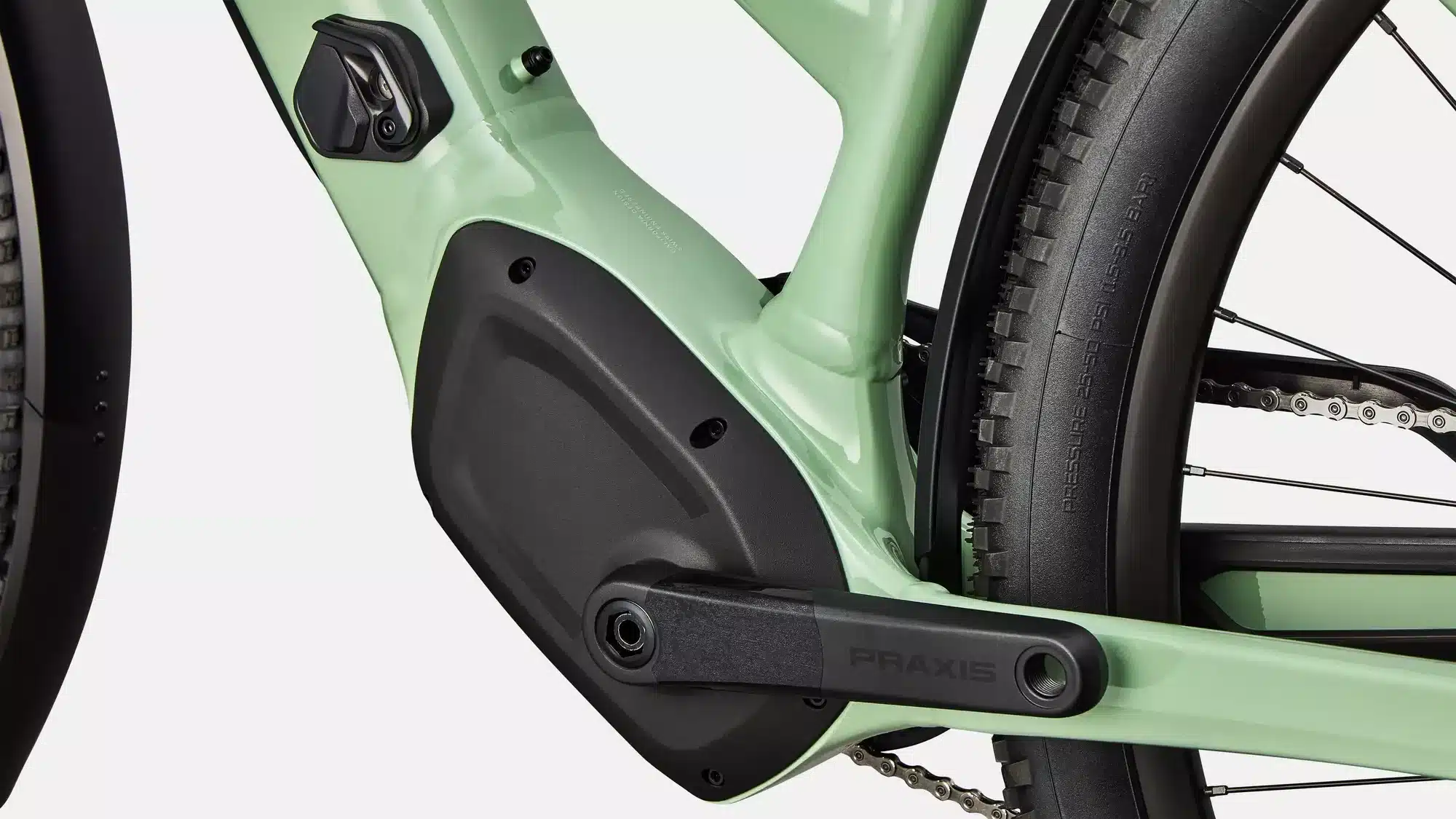 Nahaufnahme des mintgrünen Rahmens eines Specialized Turbo Tero 4.0 EQ E-Bikes, Fokus auf das Kurbelgehäuse, den integrierten Motor und den Teil des Hinterrads.