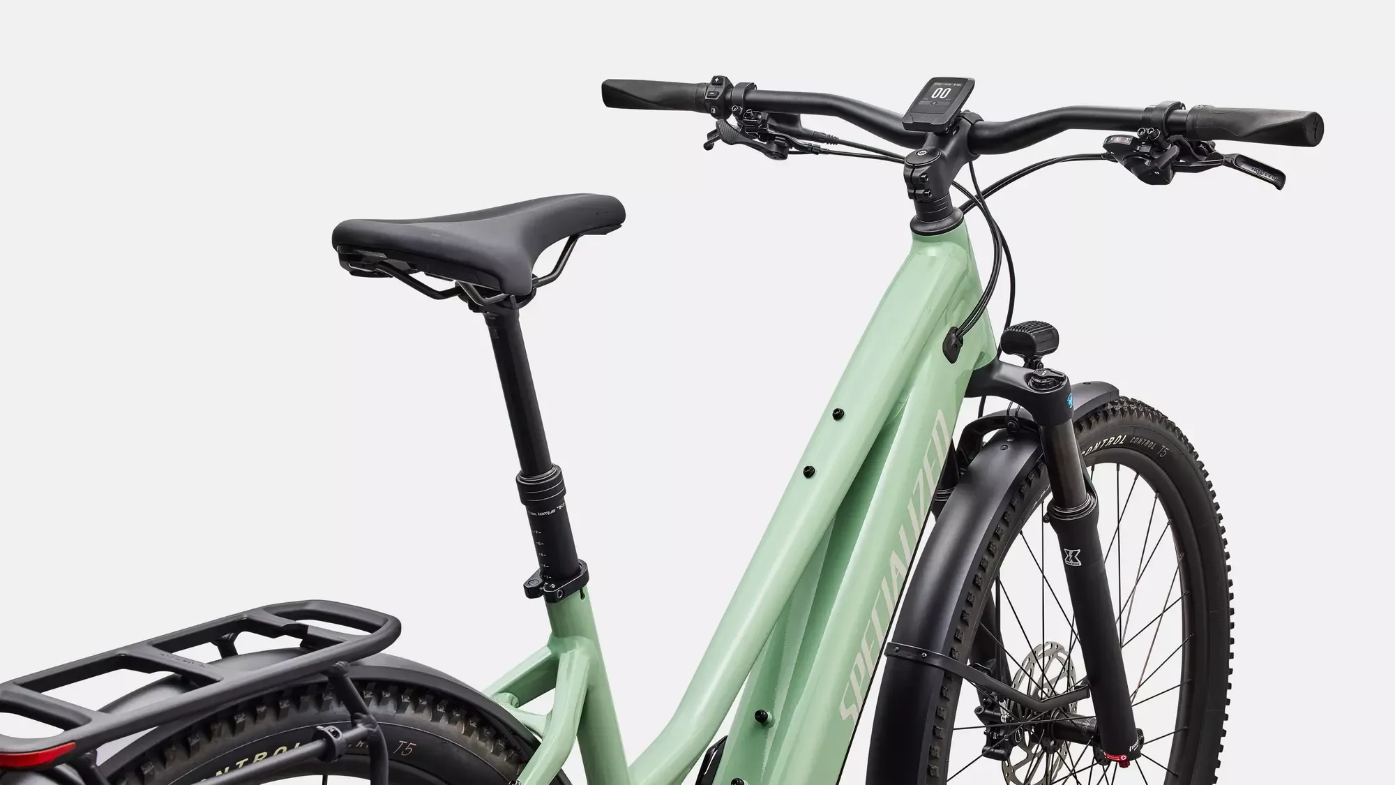 Vorderansicht eines hellgrünen Specialized Turbo Tero 4.0 Step-Through EQ Elektrofahrrads mit schwarzem Gepäckträger, Federgabel und Lenkerdisplay.