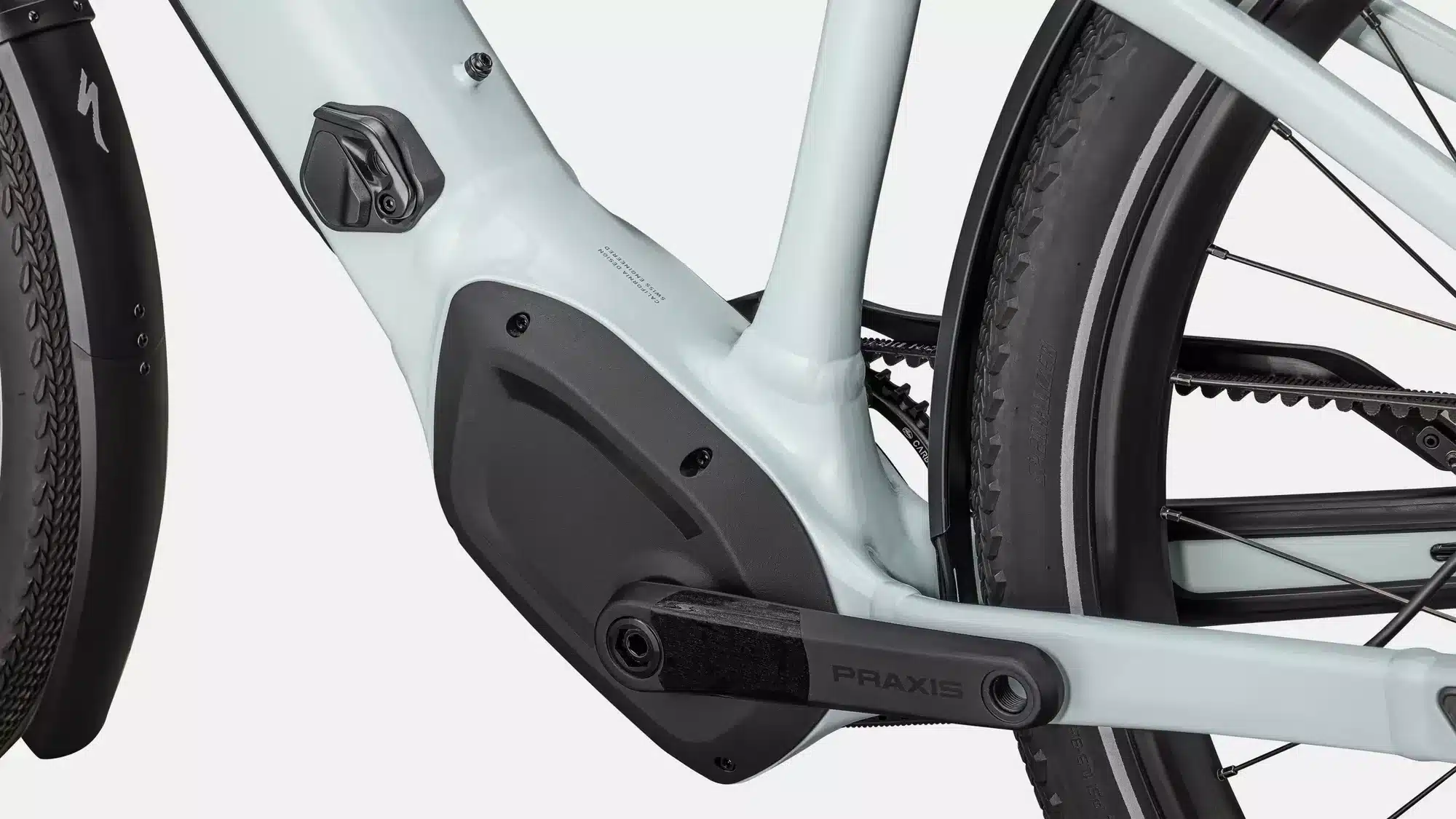 Detailaufnahme des Tretlagerbereichs eines hellgrünen Specialized Turbo Vado 4.0 IGH E-Bikes mit schwarzer Kurbelgarnitur der Marke Praxis, dem integrierten Specialized 2.0 Motorgehäuse und einem Gates Carbon Drive CDX Riemenantrieb.
