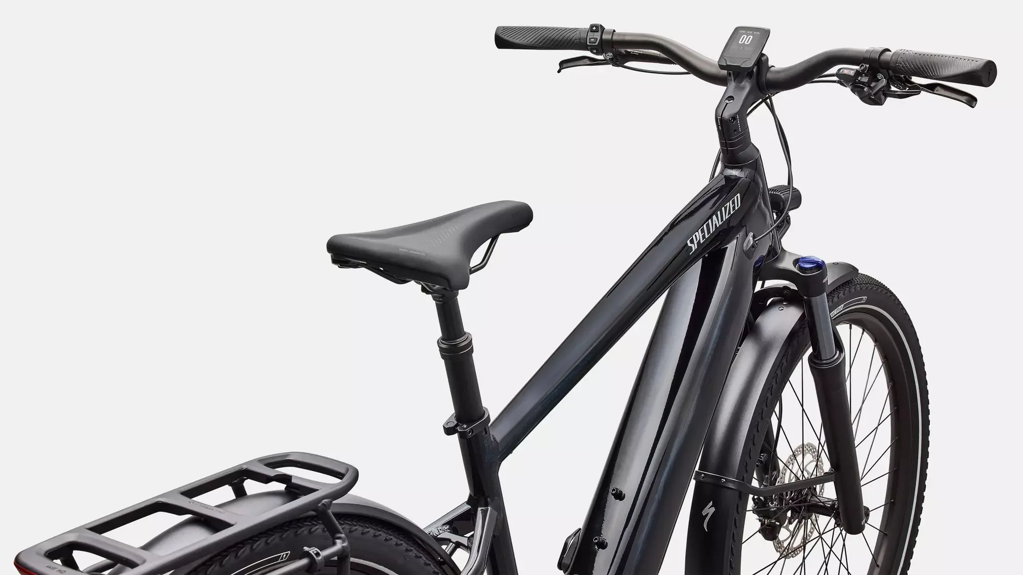 Nahaufnahme eines schwarzen Specialized Turbo Vado 4.0 E-Bikes, das den Rahmen mit integriertem Akku, den Sattel, den Lenker mit Display und die Vorderradfederung zeigt.