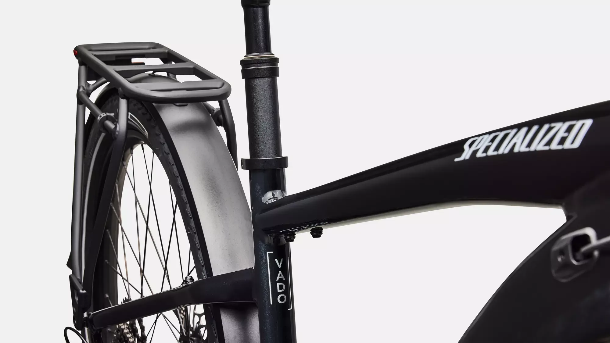 Nahaufnahme des Rahmens eines schwarzen Specialized Turbo Vado 4.0 E-Bikes mit integriertem Gepäckträger und Schutzblech.