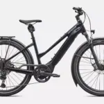 Schwarz glänzendes Specialized Turbo Vado 5.0 Step-Through E-Bike mit Gepäckträger und Schutzblechen, von der Seite betrachtet.