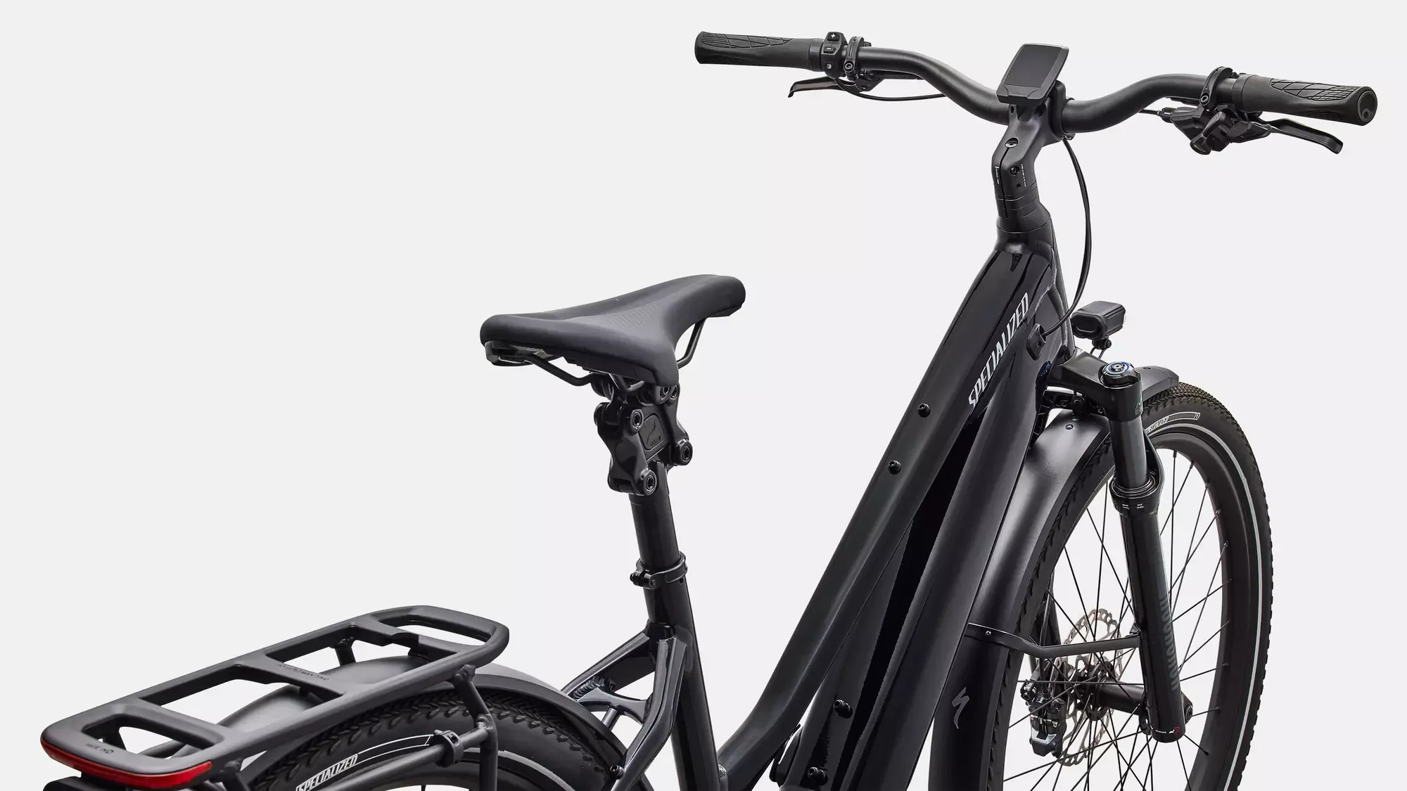 Schwarz lackierter Rahmen eines Specialized Turbo Vado 5.0 Step-Through E-Bikes mit Fokus auf die Federgabel, den Sattel, die Sattelstütze und den Gepäckträger.