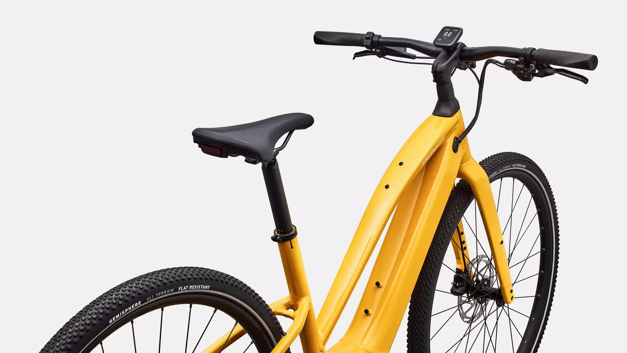 Nahaufnahme eines gelben Specialized Turbo Vado SL 2 4.0 Step-Through E-Bikes, gezeigt von der Seite mit Blick auf den Rahmen, die Sattelstütze und das Lenkerdisplay.