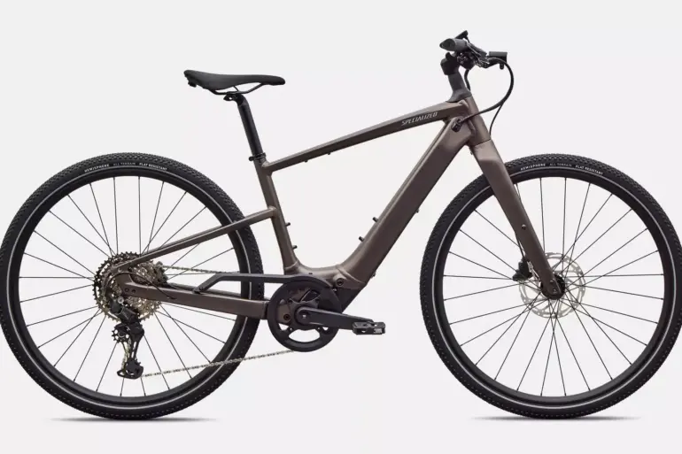 Ein seitliches Profilbild eines Specialized Turbo Vado SL 2 4.0 E-Bikes in Satin Gun Metal Farbe, mit Fokus auf den Rahmen, die Reifen und die elektrische Unterstützung.