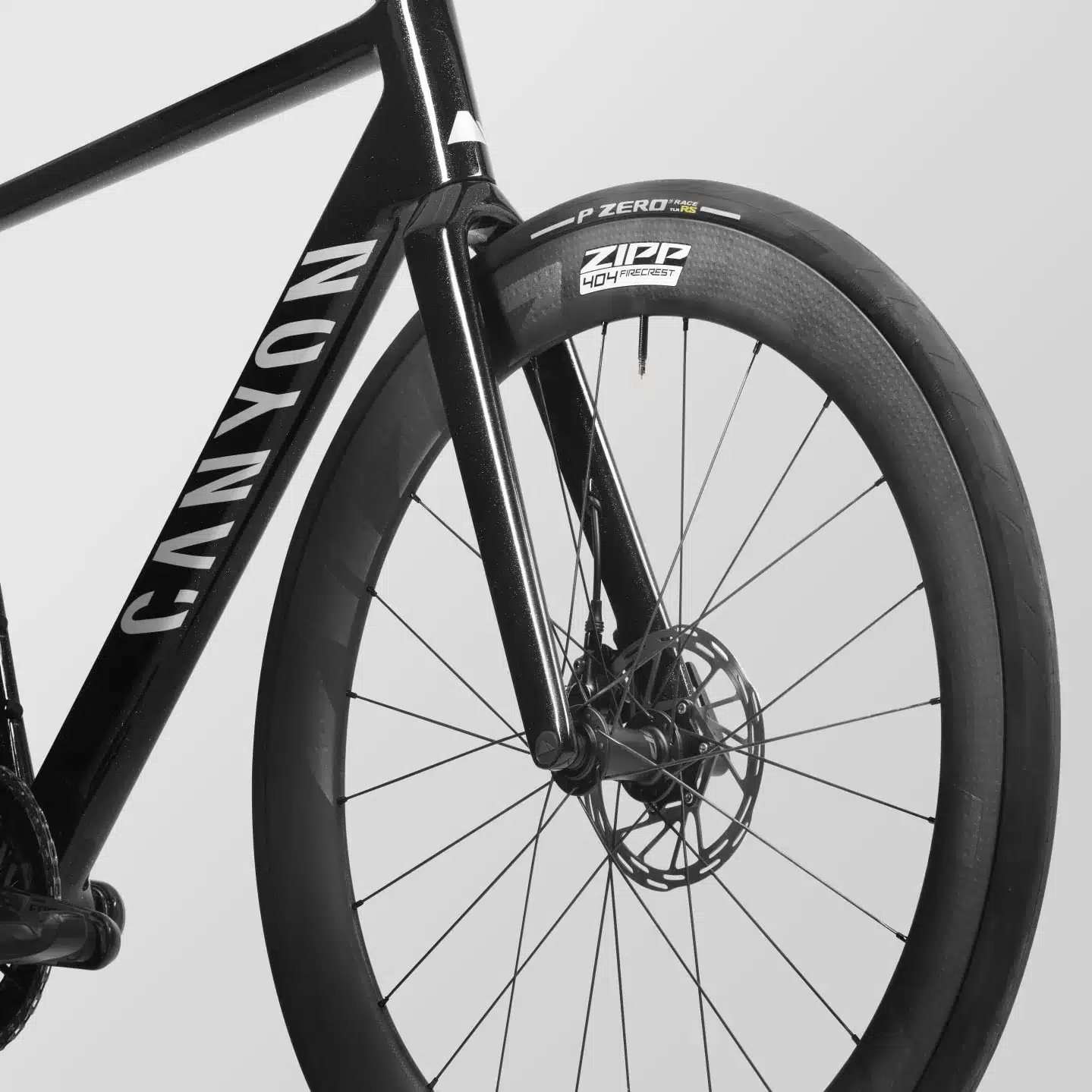 Nahaufnahme eines schwarzen Canyon Rennrads, Fokus auf die Vorderradgabel und das Vorderrad mit Zipp 404 Firecrest Carbon-Felge.