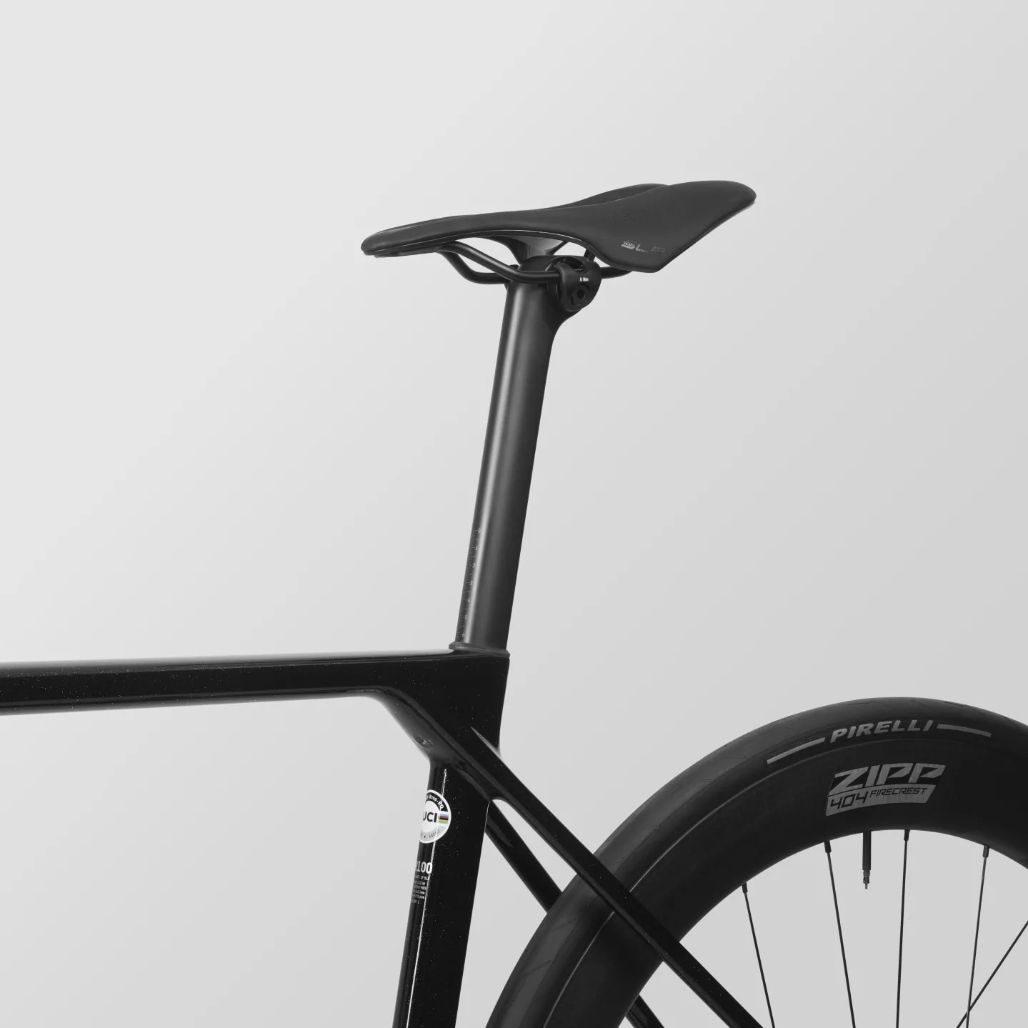 Detailaufnahme des Hinterrads eines Canyon Ultimate CF SLX 8 AXS Rennrads, das mit einem Zipp 404 Firecrest Carbon-Laufrad und einem Pirelli-Reifen ausgestattet ist. Der Rahmen ist aus Carbon gefertigt und zeigt das Canyon-Logo sowie UCI-Aufkleber. Ein schlanker schwarzer Sattel mit der Marke