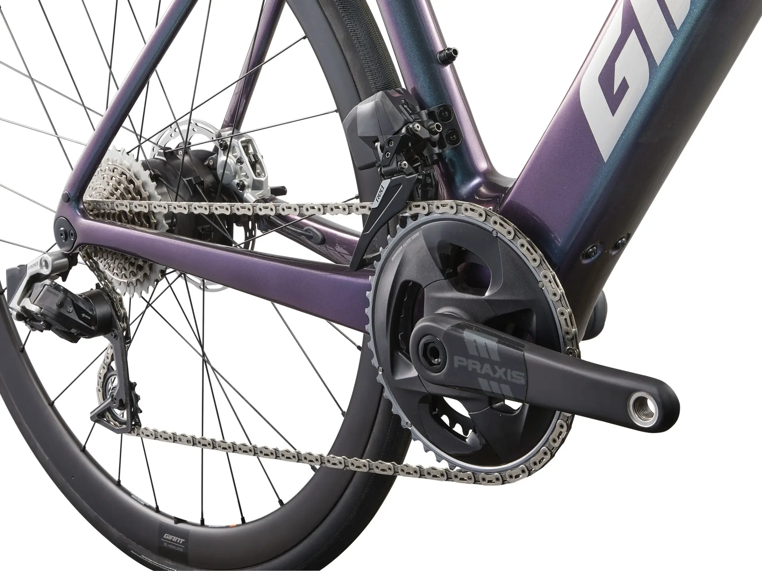 Detailaufnahme des Antriebsstrangs eines lila metallisch glänzenden Giant Defy Advanced E+ Elite 0 Rennrads, inklusive Kette, Kassette, Schaltwerk und Hinterradnabe.
