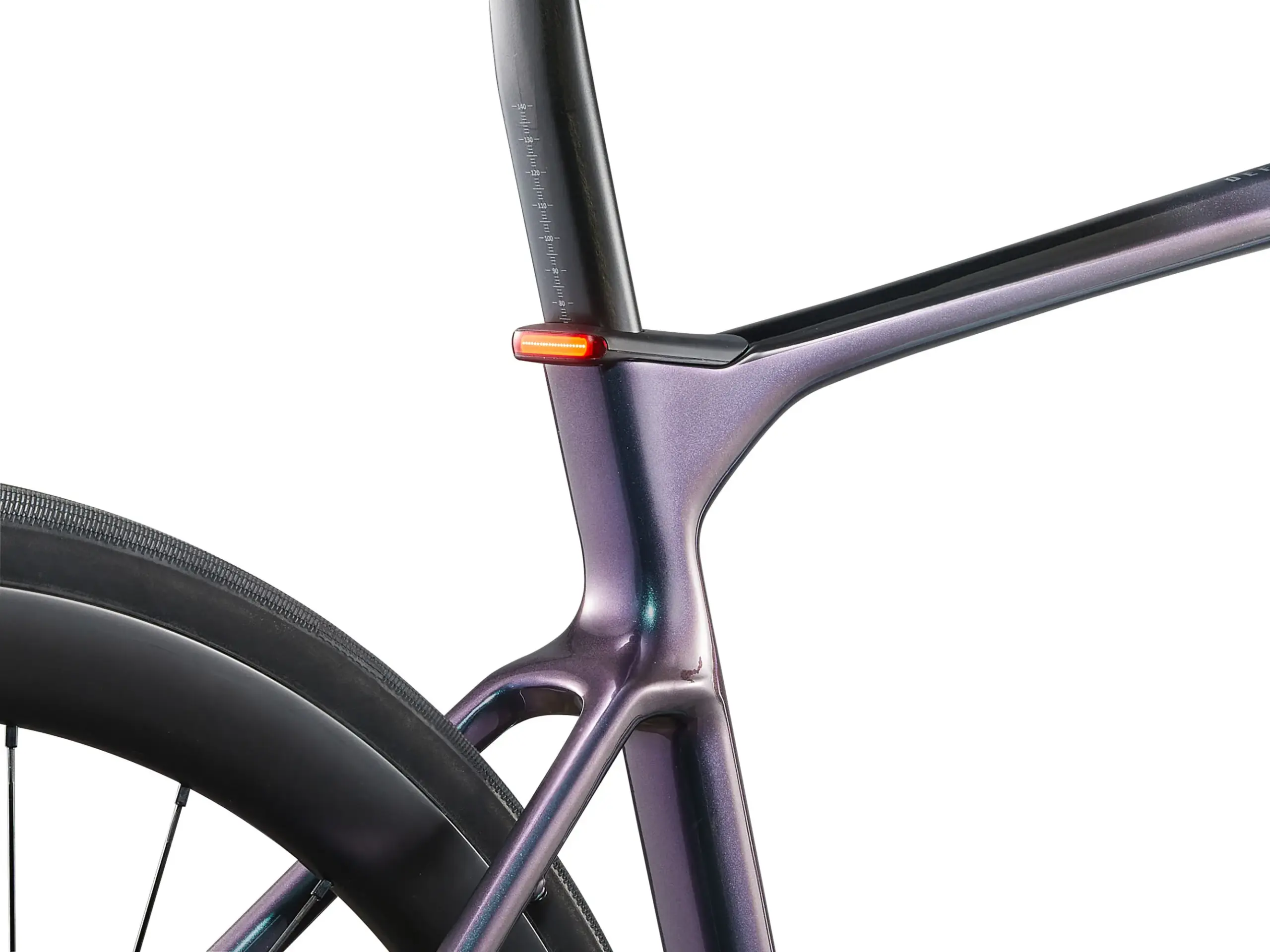 Nahaufnahme des hinteren Rahmensegments eines lila-metallic glänzenden Giant Defy Advanced E+ Elite 0 E-Rennrads, fokussiert auf die Aussparung für die Sattelstütze mit einem integrierten roten LED-Rücklicht und der Fahrradfelge mit Speichen.