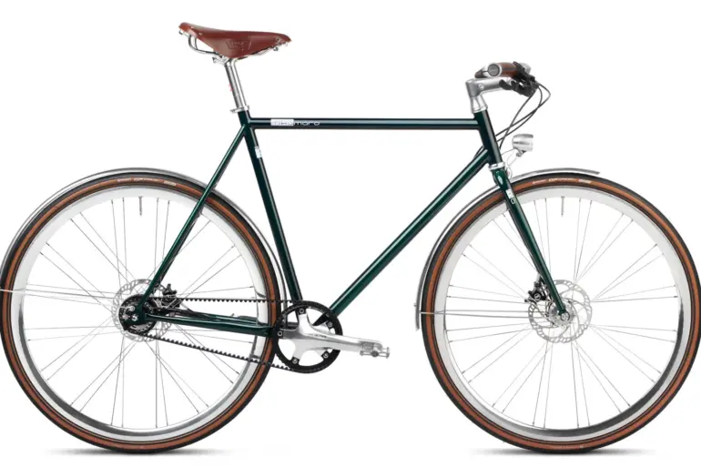 Grünes Emerald Green Urban Deluxe Fahrrad im Seitenprofil, mit Fokus auf den Columbus-Stahlrahmen, Gates Carbon Drive Riemenantrieb und Brooks Ledersattel.