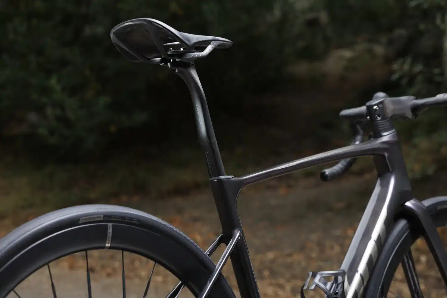 Nahaufnahme des dunklen Carbonrahmens und des Hinterrads eines Giant Defy Advanced SL 0 Endurance-Rennrads, mit Fokus auf die Sattelstütze und den Sitzbereich.