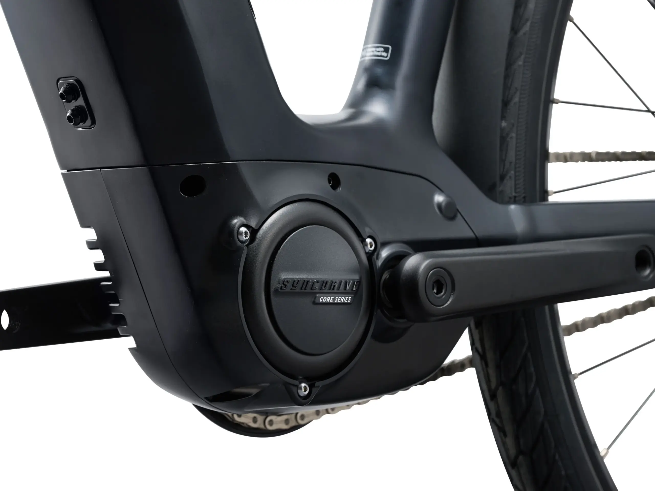 Nahaufnahme des schwarzen E-Bike-Motors mit der Aufschrift 'SyncDrive CORE SERIES'. Daneben ist die Kurbelgarnitur und ein Teil der Fahrradkette zu sehen.