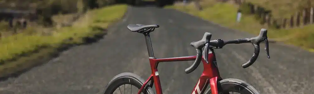 Rotes Giant Propel Advanced Pro Aero-Rennrad mit tiefen Carbonfelgen, das auf einer asphaltierten Landstraße steht.