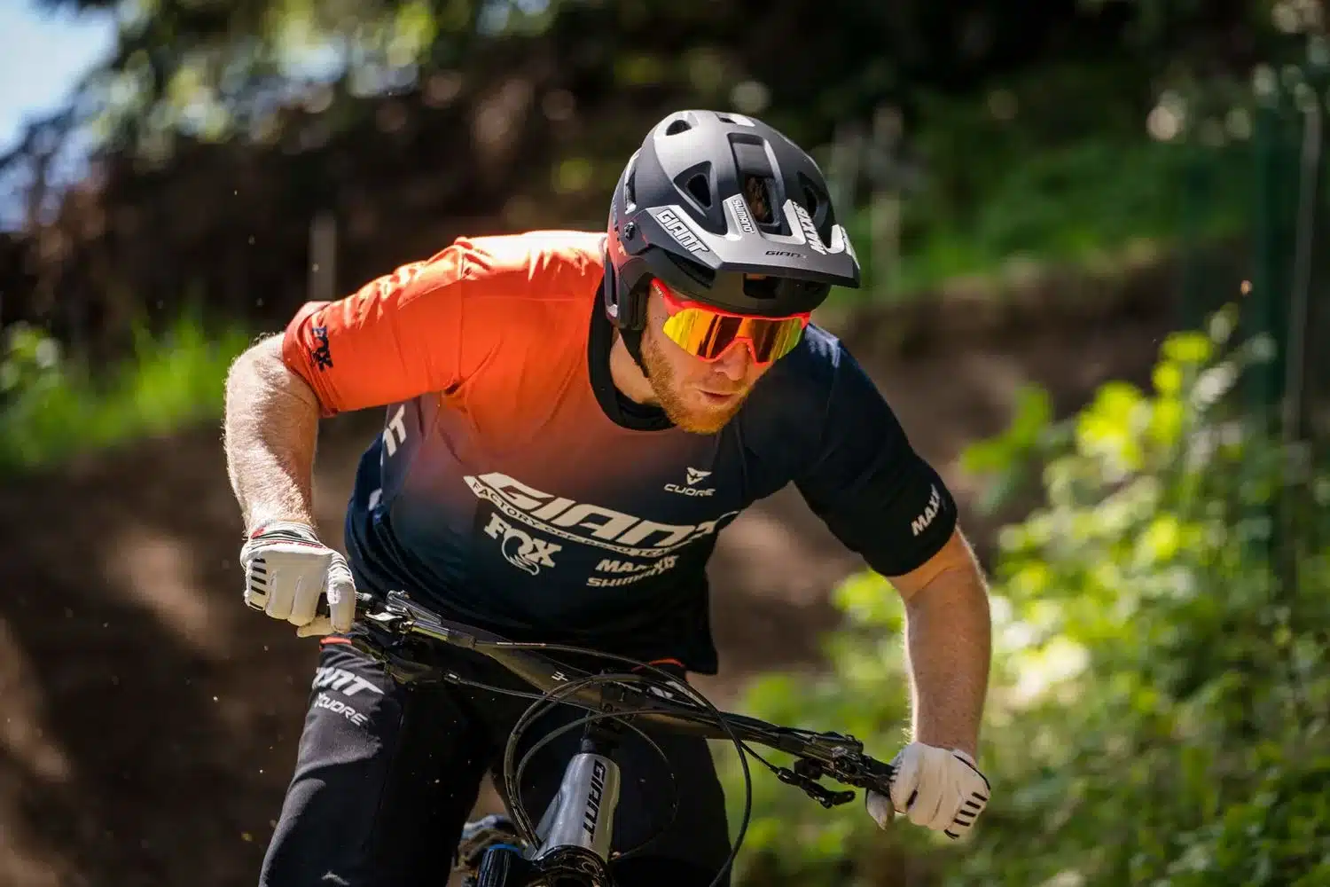 Ein Mann fährt Mountainbike und trägt einen schwarzen Fullface-Helm der Marke Giant.