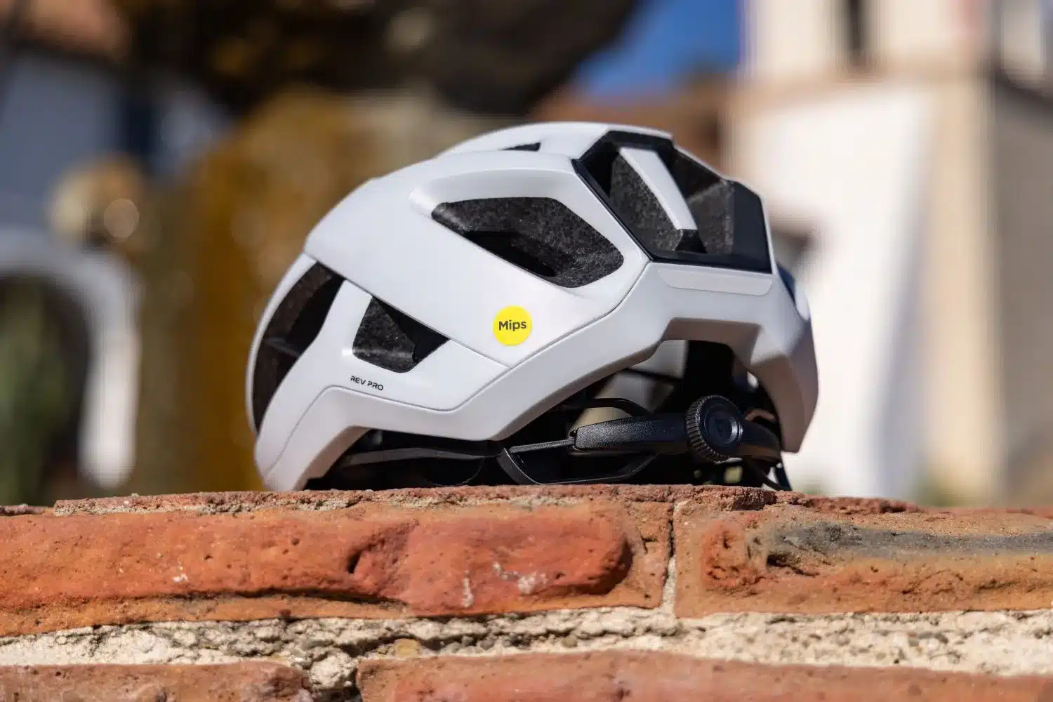 Weißer Giant Rev Pro Rennradhelm mit Mips-Aufkleber, von der Seite fotografiert.